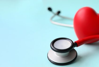 Red stethoscope with heart on blue modern background. Medical insurance concept